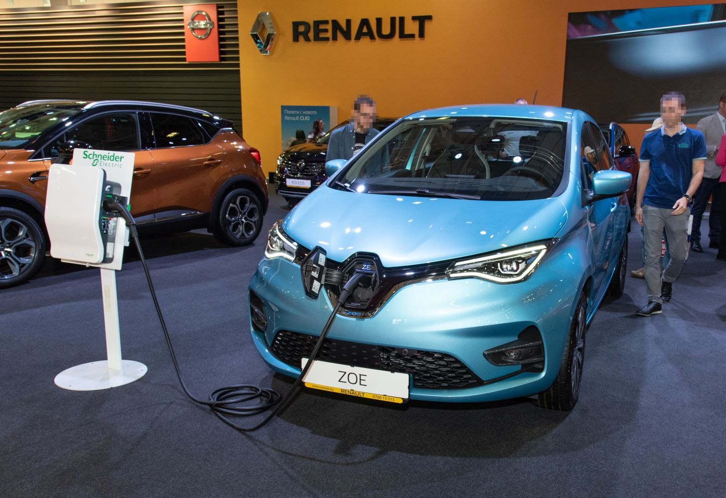 Blue electric vehicle charging at station, Renault showroom display
