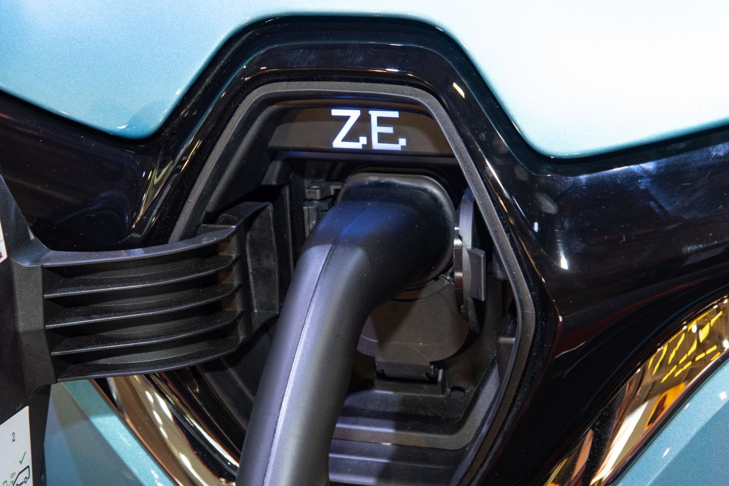 Close-up of an electric vehicle charging port with a plug inserted.