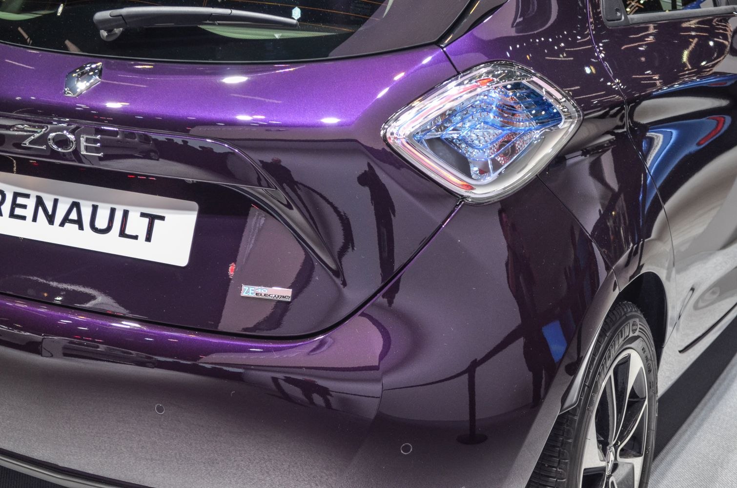 Electric vehicle badge and tail light on glossy rear panel