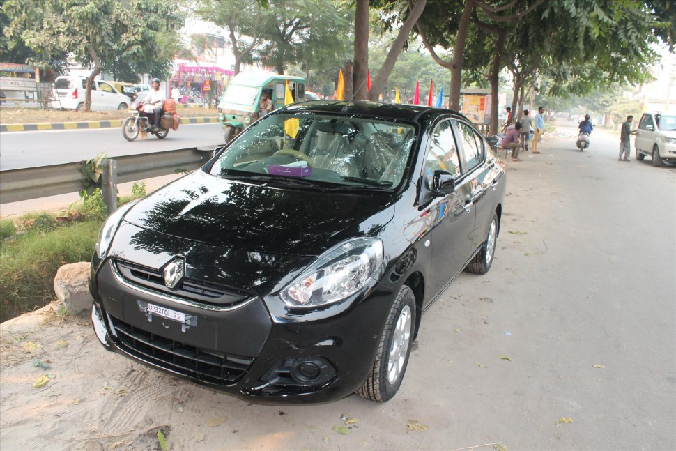 Black sedan showing front and side exterior views parked by roadside.