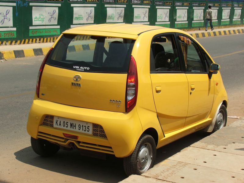Yellow compact hatchback rear view with vertical taillights.