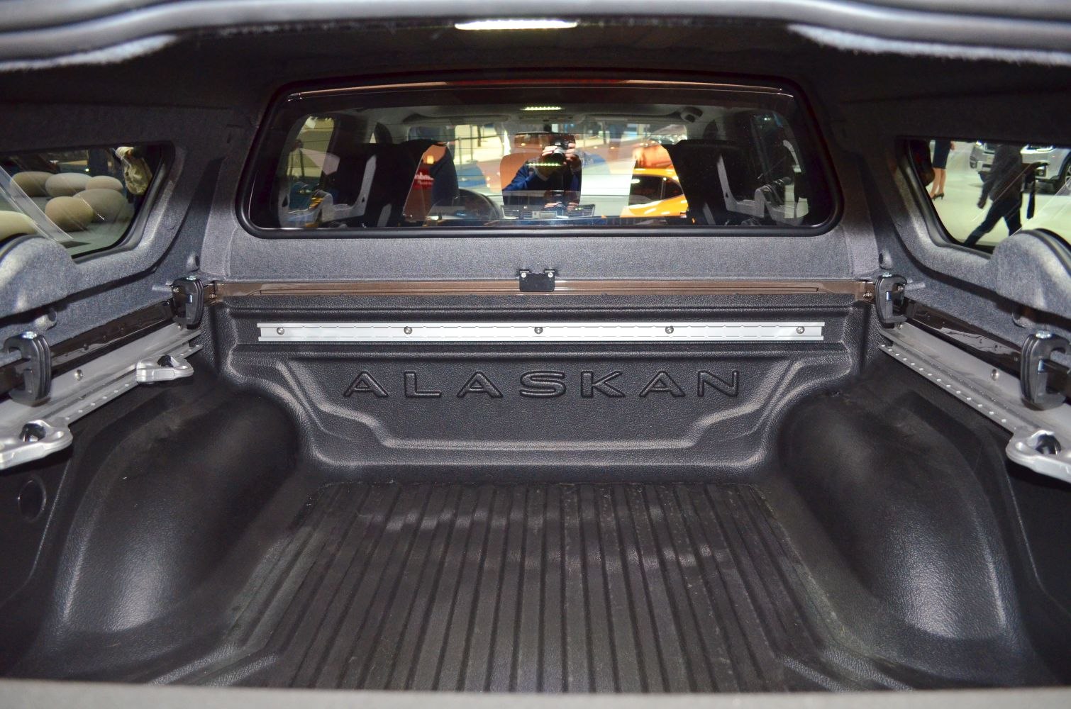 Pickup truck cargo bed with protective lining and window.