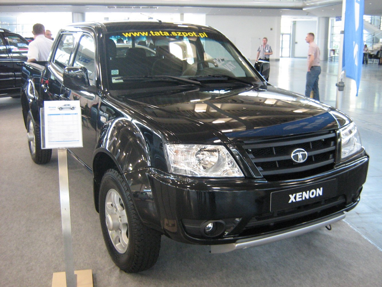 Front and side view of a black pickup truck indoors.