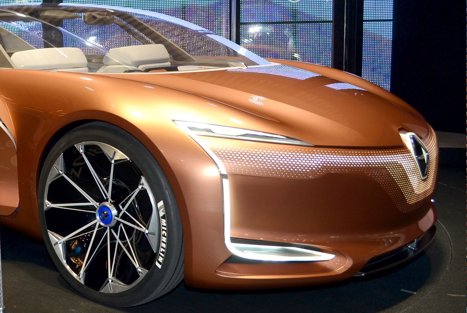 Sleek front LED lights and intricate alloy wheel design on futuristic vehicle