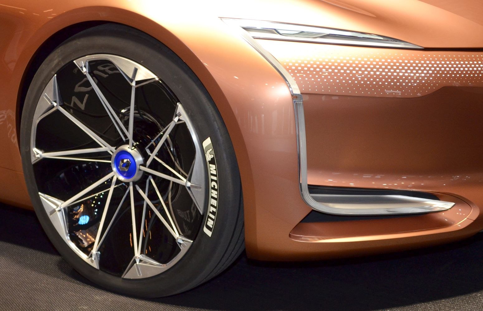Futuristic front wheel and fender details with Michelin tire and intricate rim design