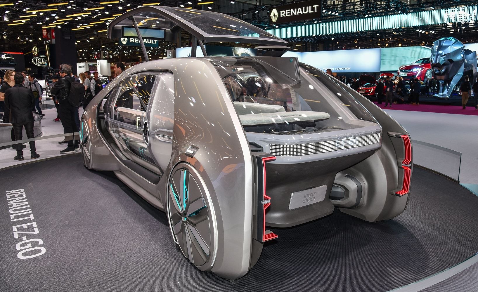 Futuristic autonomous shuttle with transparent roof and unique rear lighting.