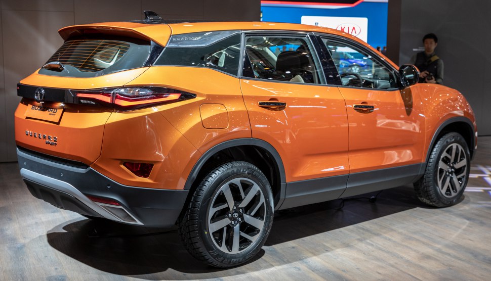 Rear side angle of an orange SUV with distinctive tail lights and alloy wheels