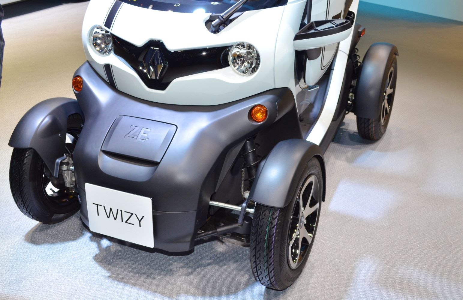 Compact electric quadricycle front with suspension and headlights