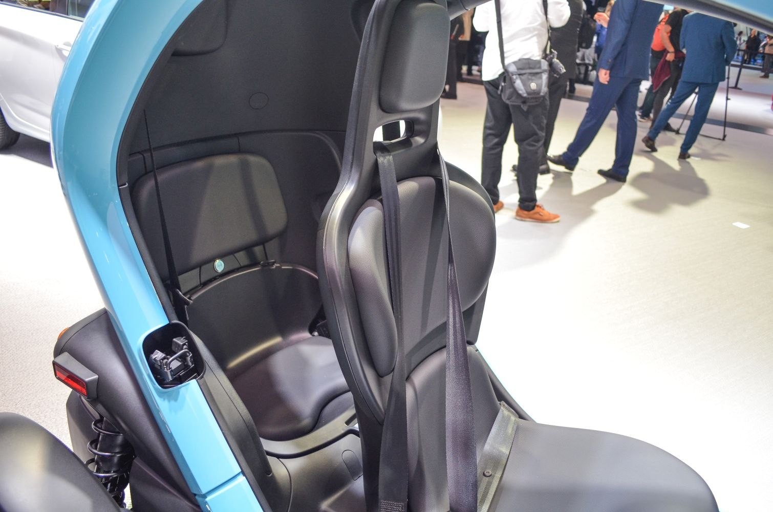 Compact electric two-seater interior with ergonomic seats and seatbelt