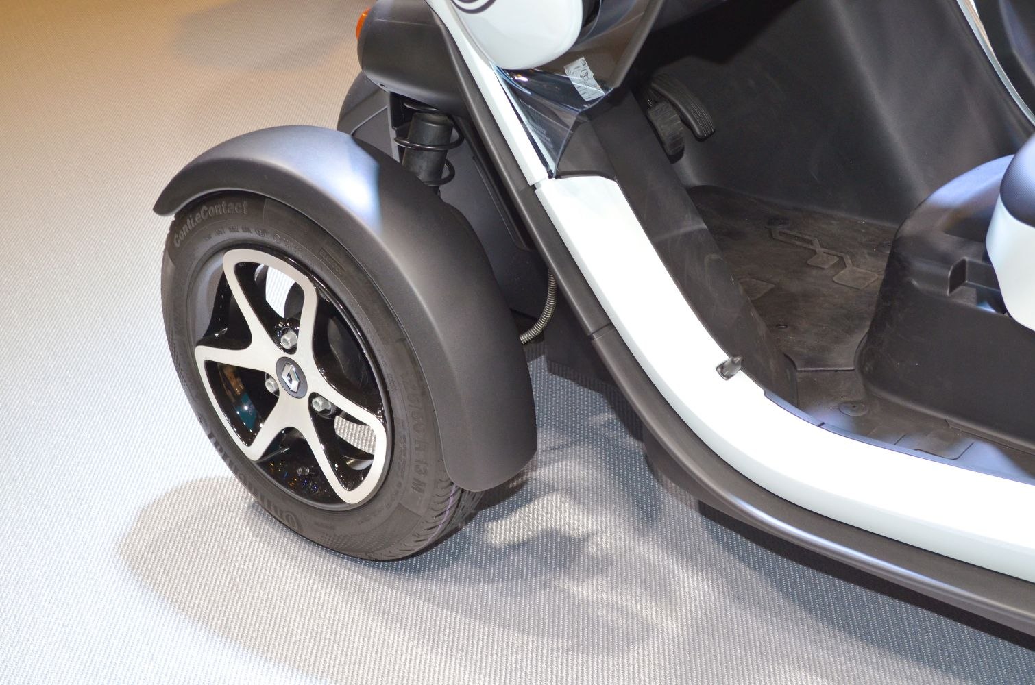 Close-up of rear wheel and footwell area of compact electric vehicle