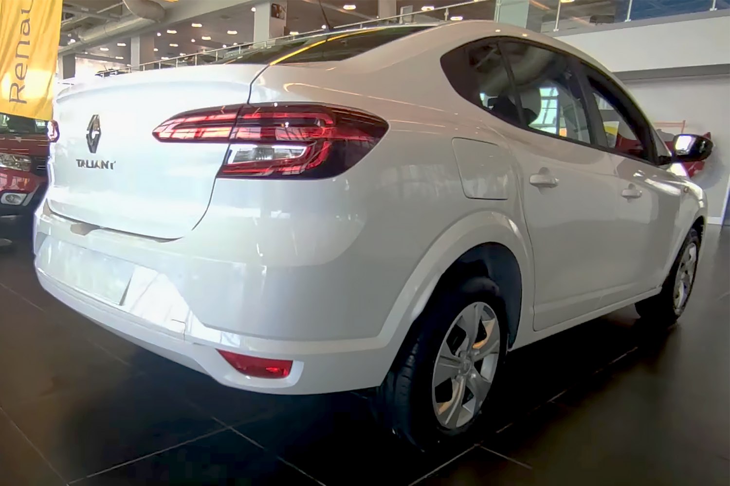 Rear and side view of a modern white sedan with distinct taillights and alloy wheels