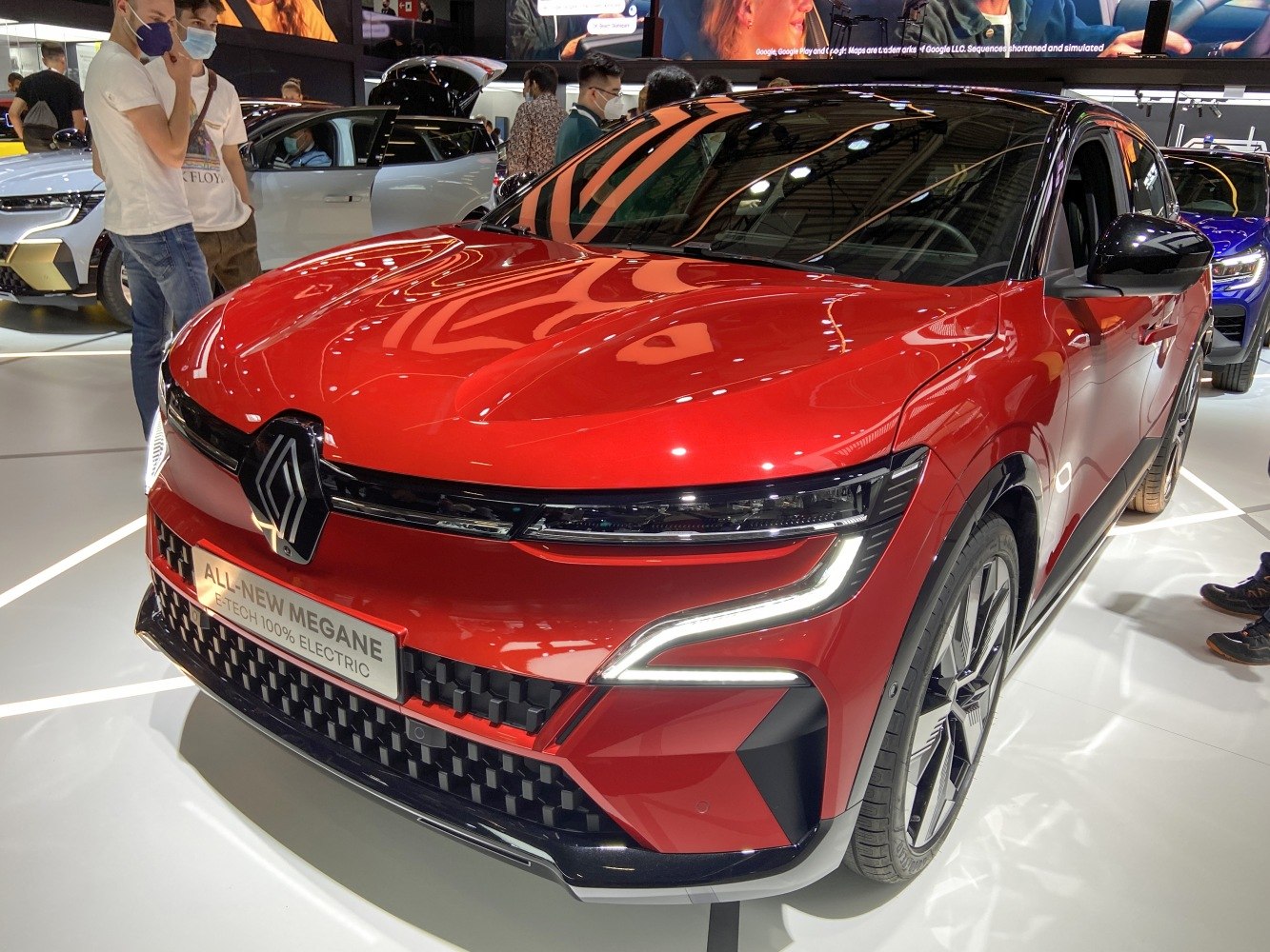 Red electric hatchback with aggressive LED headlights and modern front design