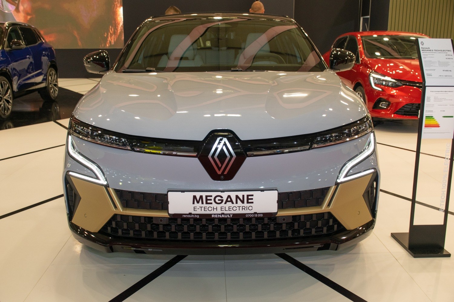 Front view of a sleek electric car with LED headlights and bold grille design