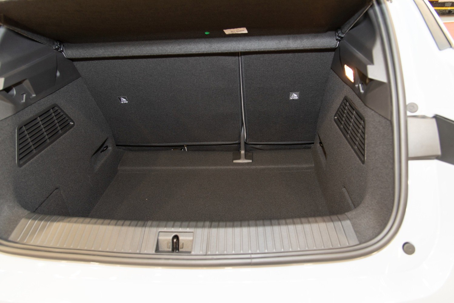 Spacious and practical car trunk interior with side vents and foldable rear seats.