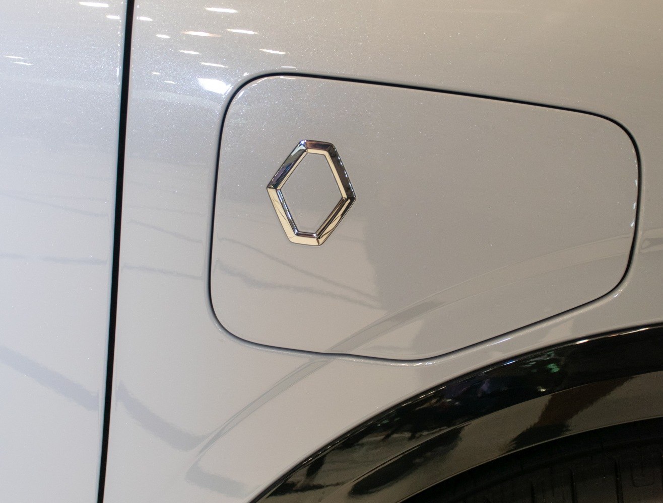 Close-up of electric vehicle fuel door with modern emblem