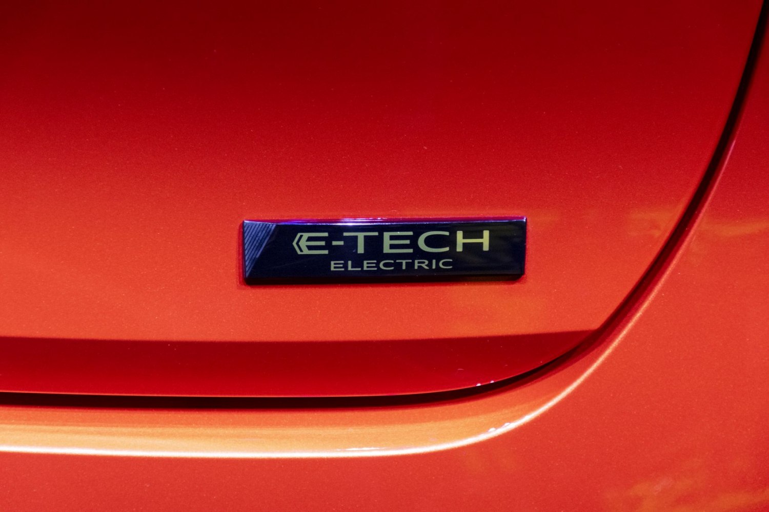 Close-up of E-Tech Electric emblem badge on car body.