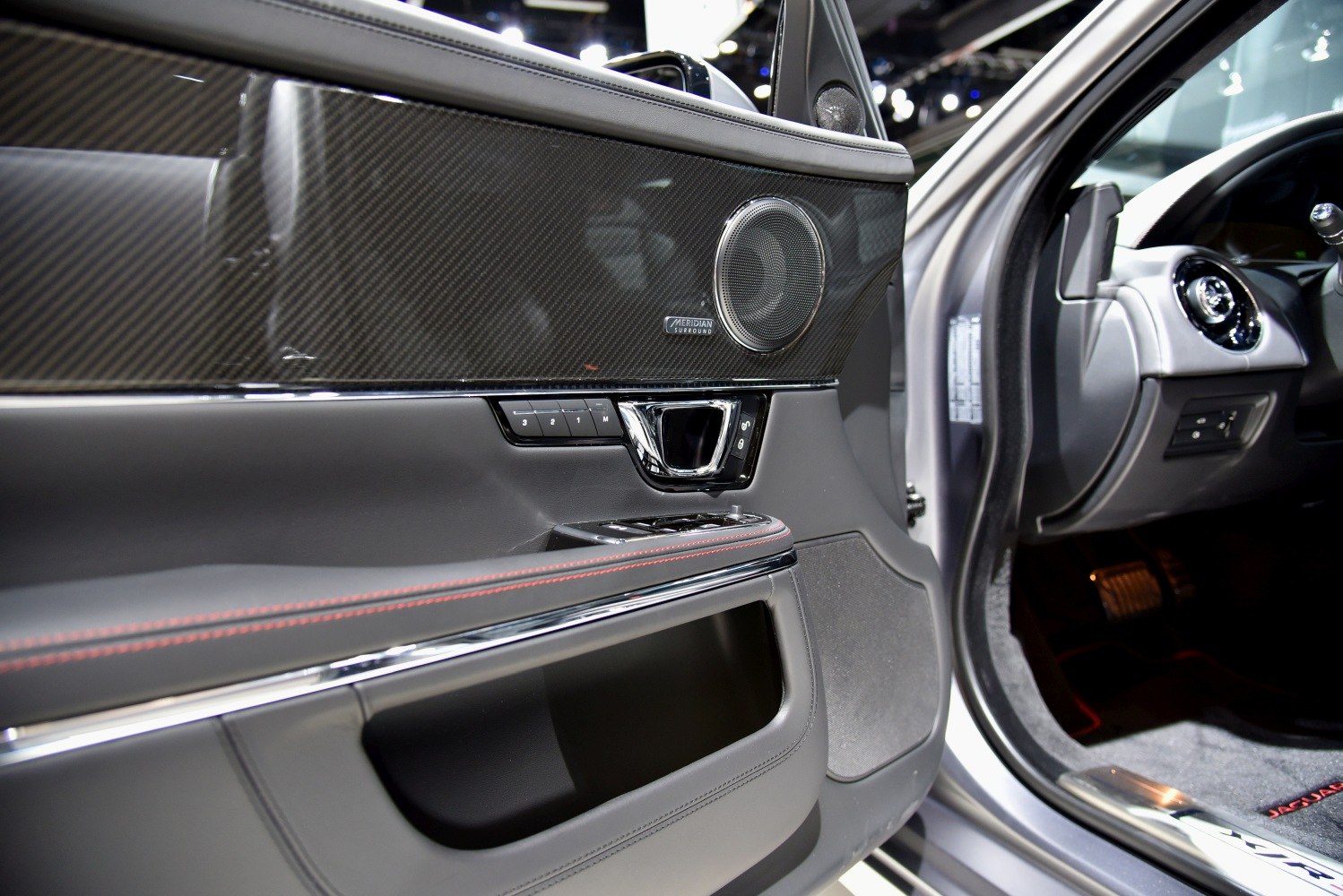 Car interior door panel with Meridian surround sound speaker and control buttons