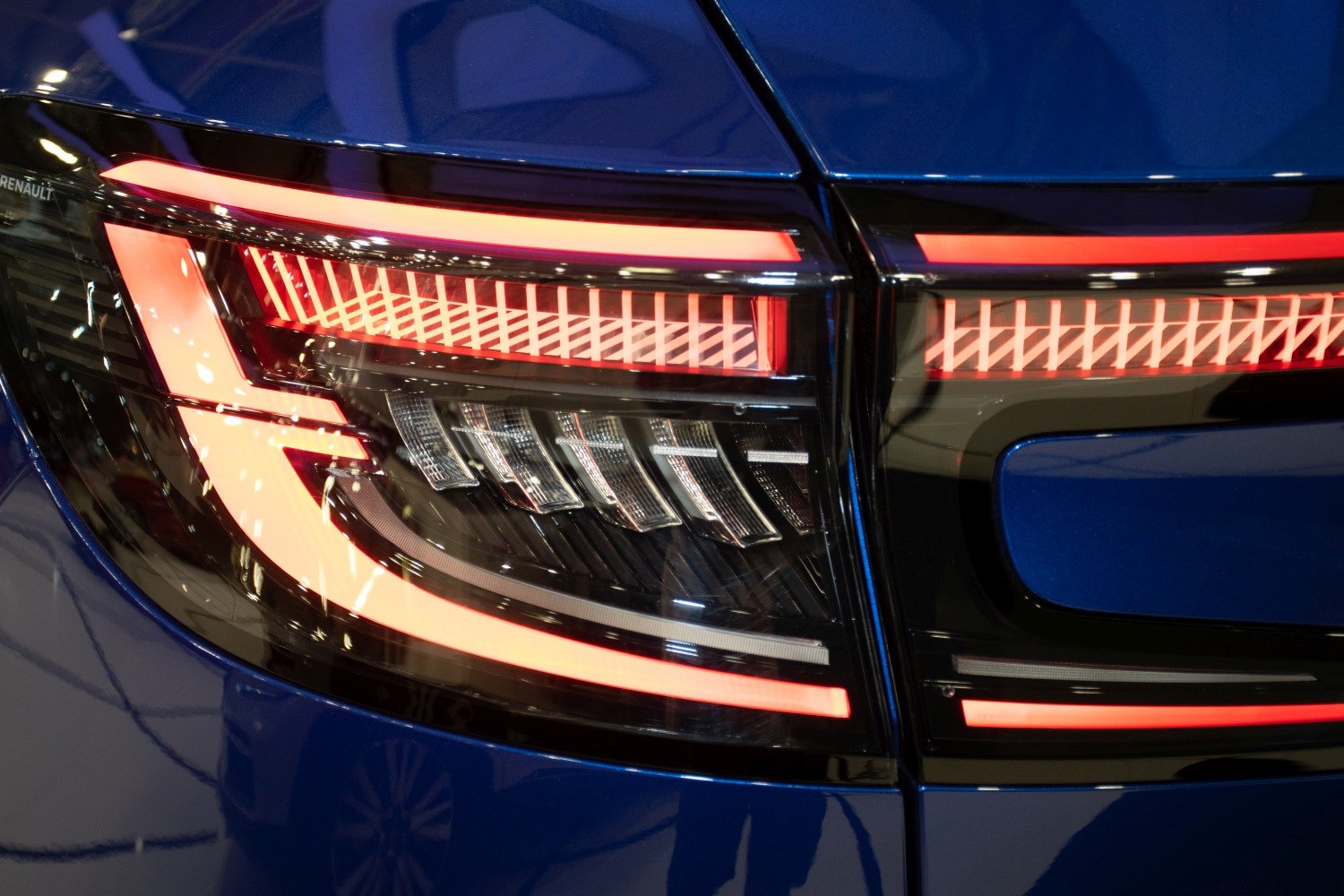 Close-up of modern LED rear lights with intricate design pattern and illumination.