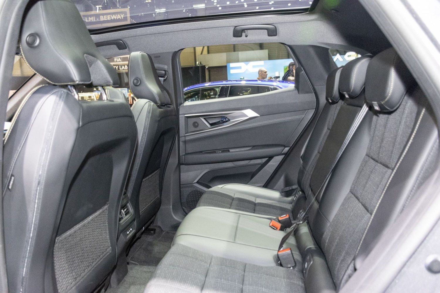 Spacious rear seating with fabric and leather upholstery, headrests, seatbelts, and door panel detail