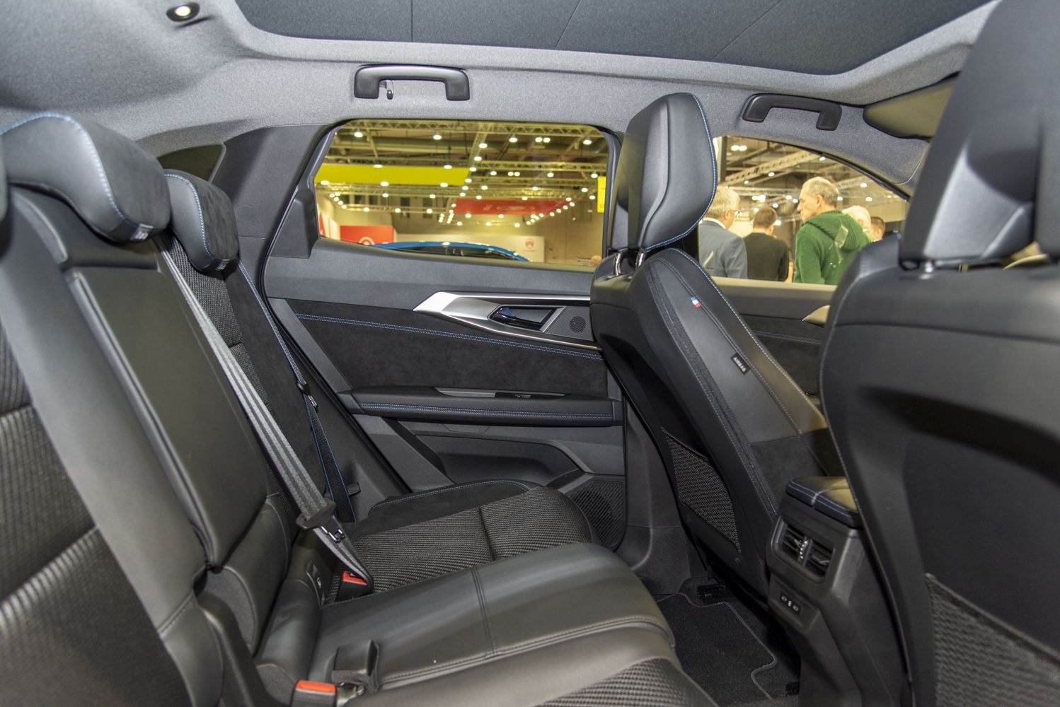 Modern rear passenger seats with upholstery and interior door panel.