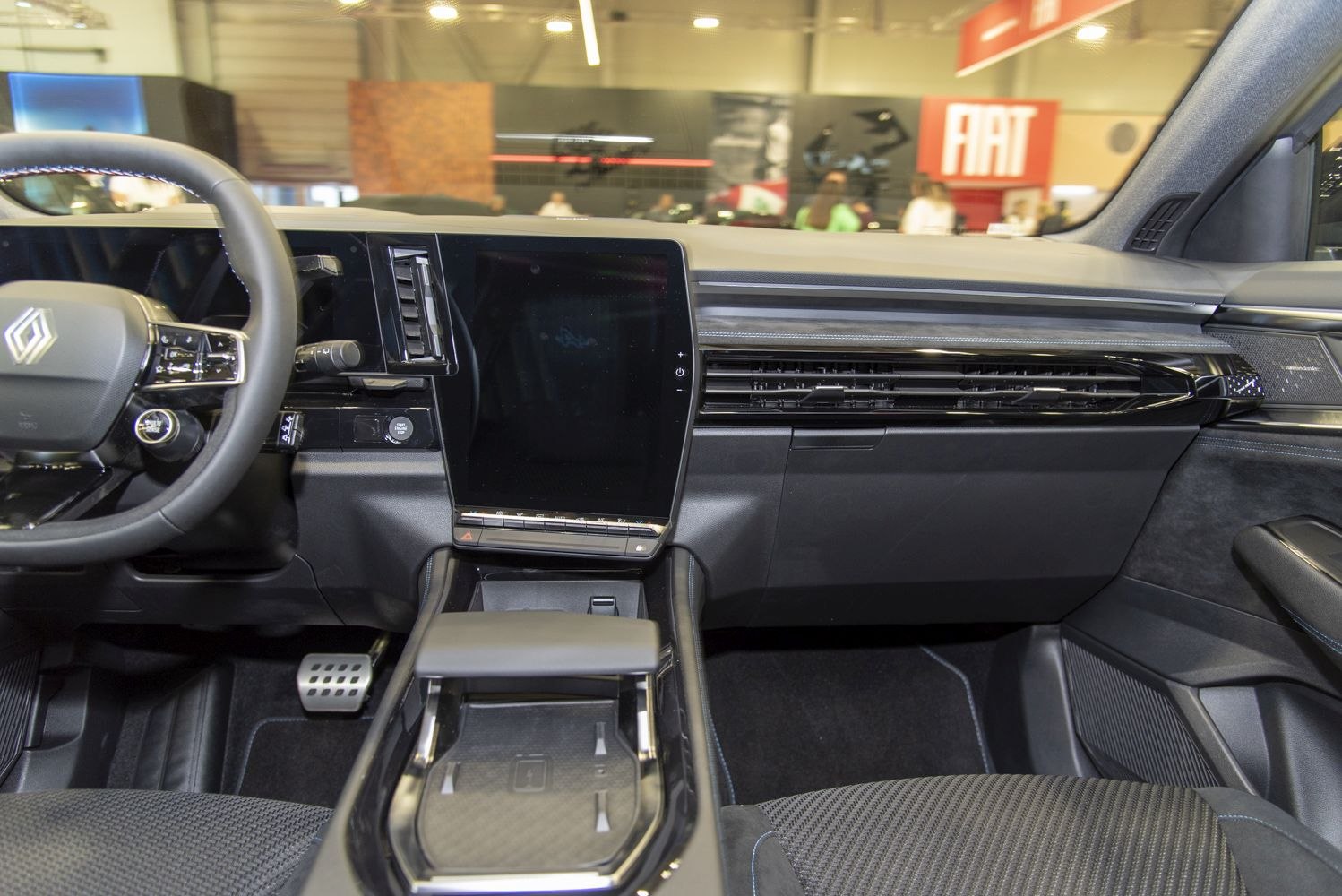 Large central touchscreen and modern steering wheel in car interior