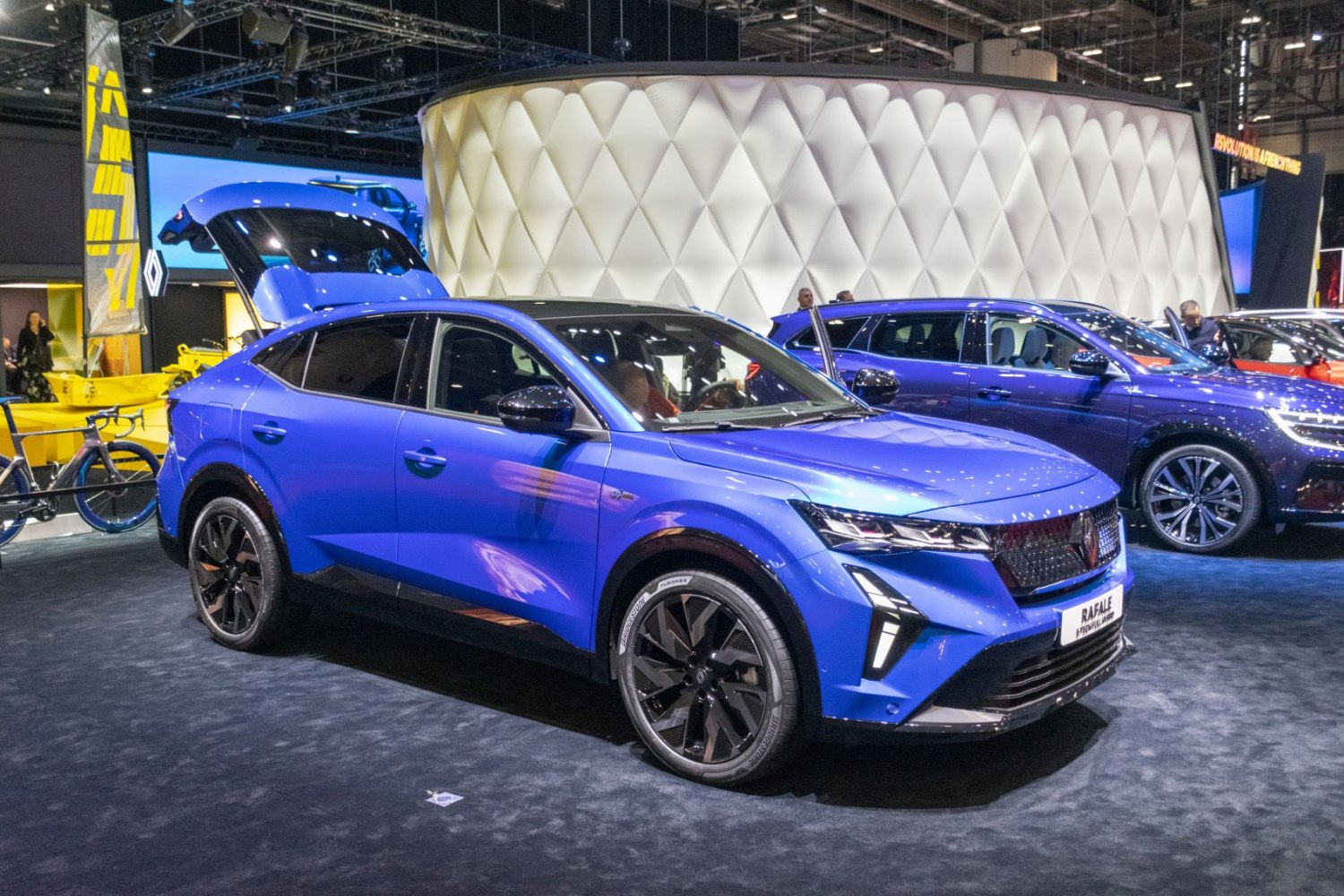 Front side view of a blue SUV with open trunk and sleek design