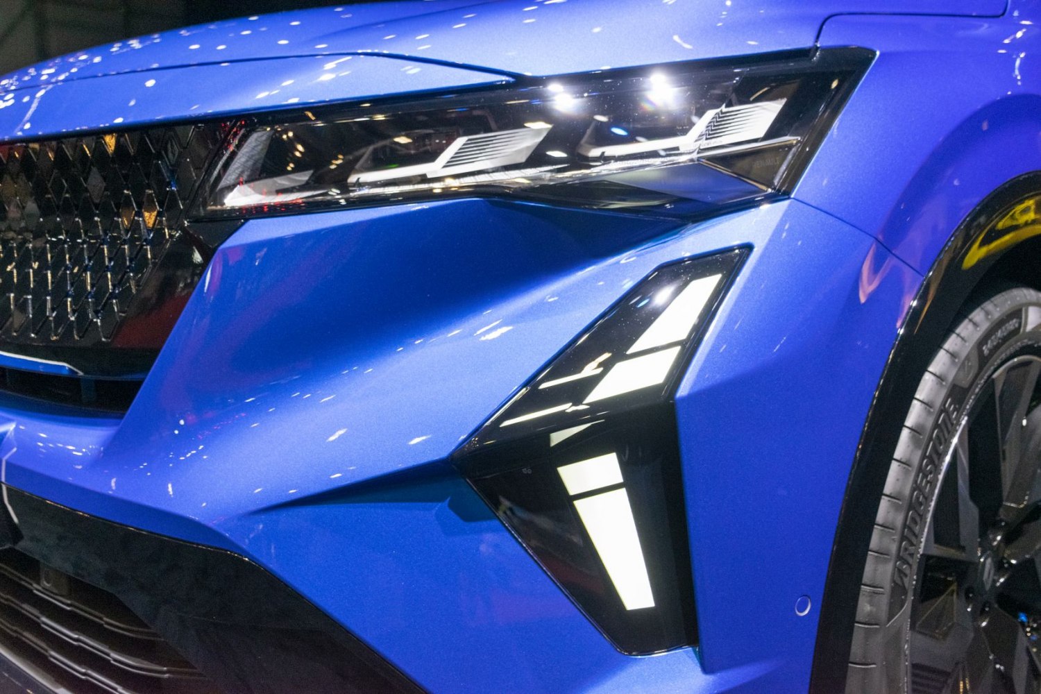 Close-up of front headlight and grille on blue modern vehicle