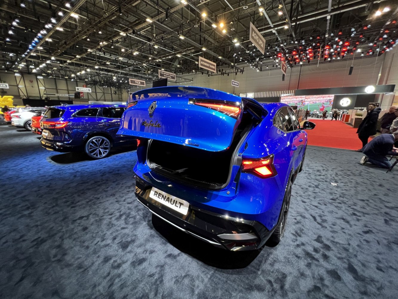 Open rear tailgate and illuminated taillights of a vibrant blue vehicle