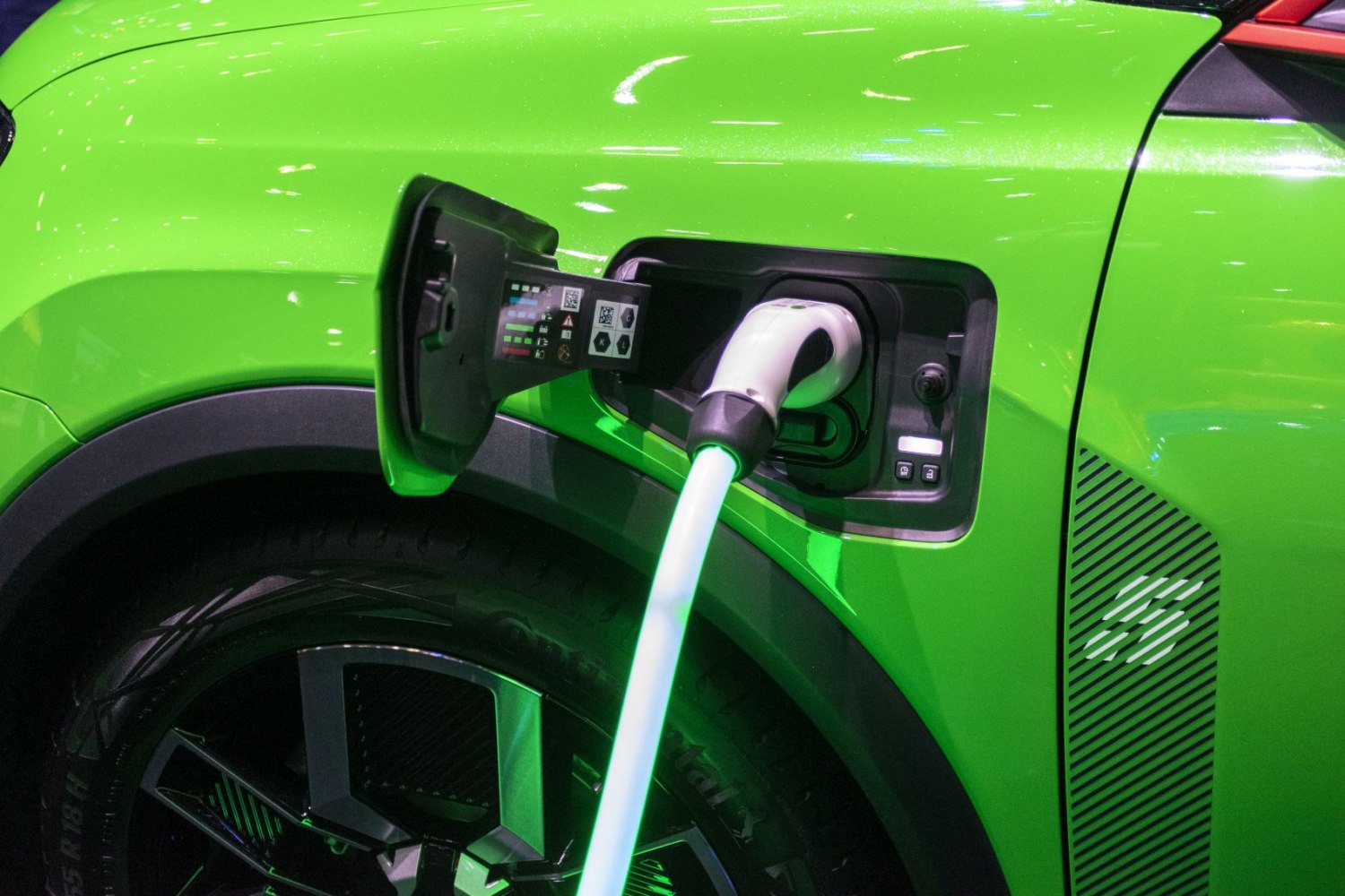 Electric vehicle charging port on a bright green hatchback