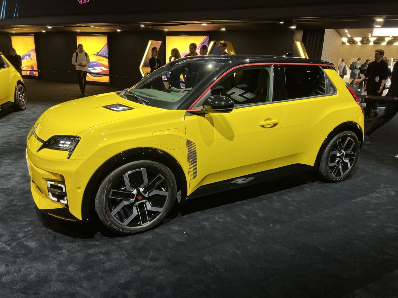 Yellow electric hatchback with black roof, unique alloy wheels, and sporty design