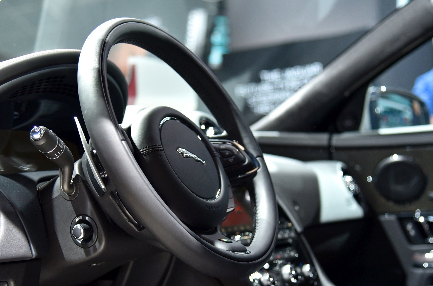 Close-up of steering wheel and interior controls with leather wrapping and paddle shifters