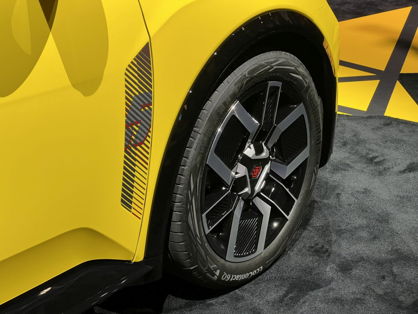 Close-up of alloy wheel and side panel decal on yellow car
