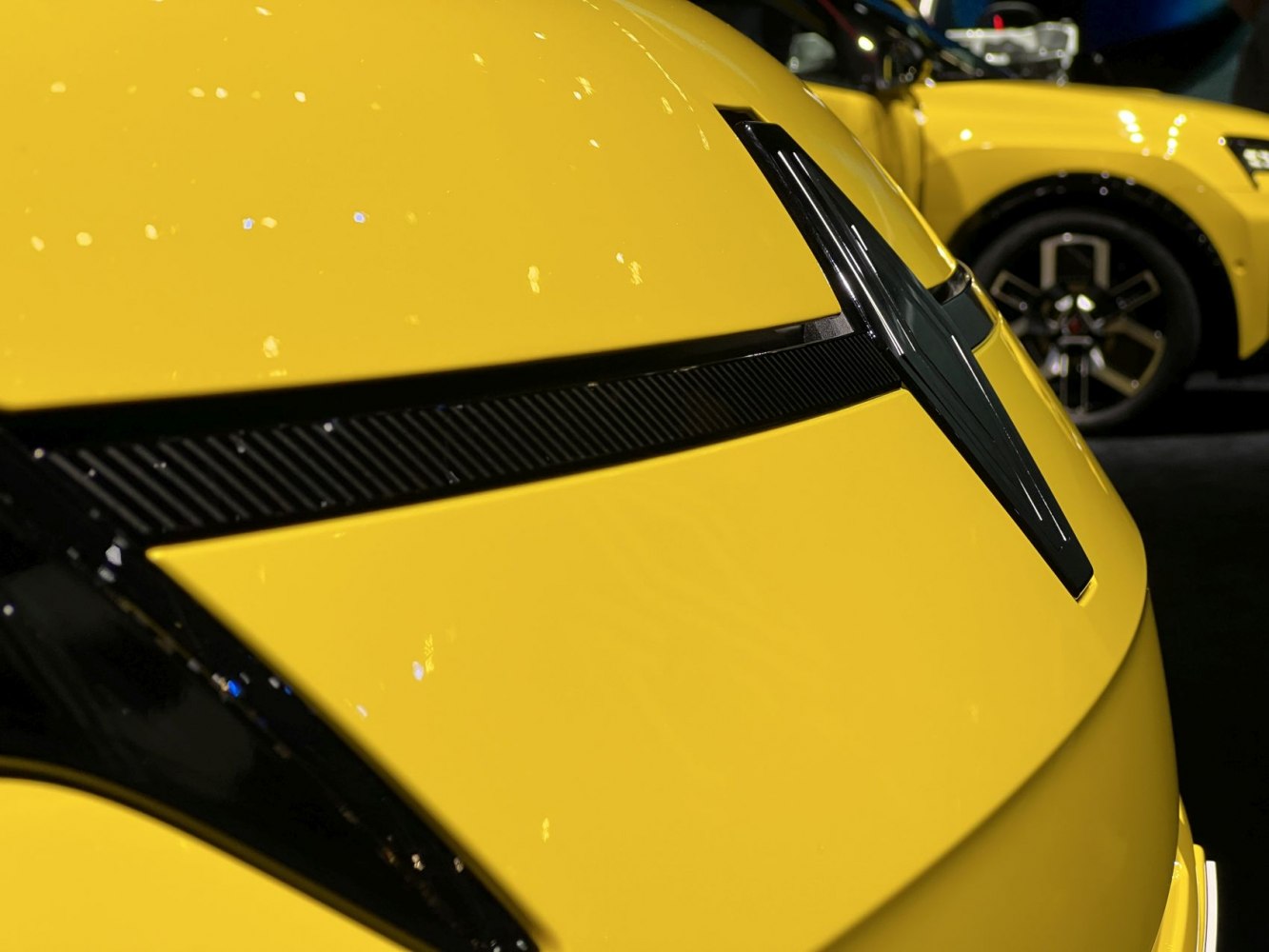 Close-up of Renault 5 E-Tech front emblem and yellow paint