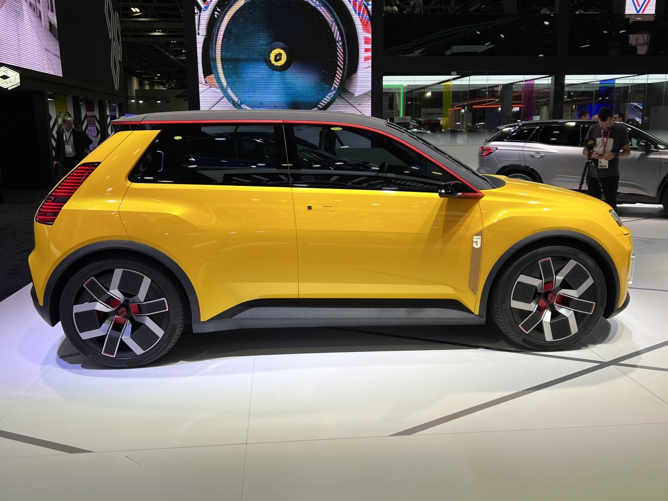Yellow compact electric hatchback with futuristic wheels side profile