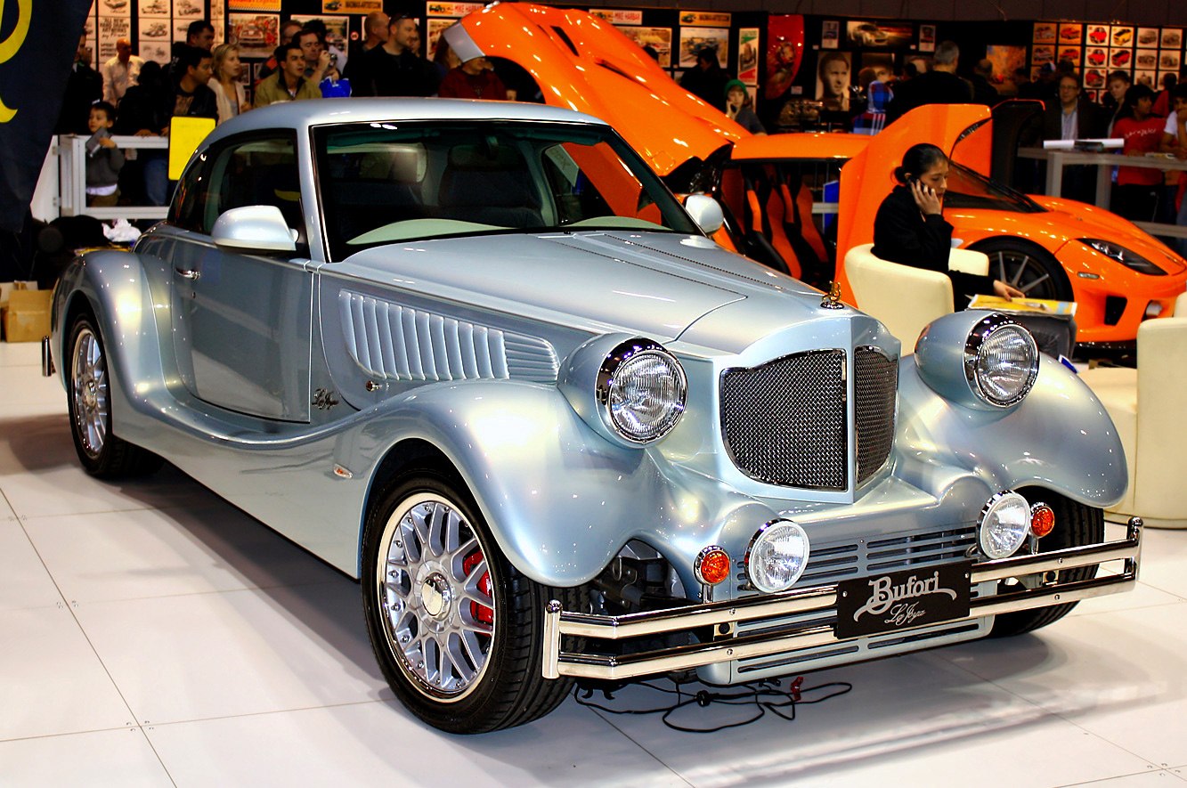 Front and side view of a vintage retro-style car with round headlights and chrome grille