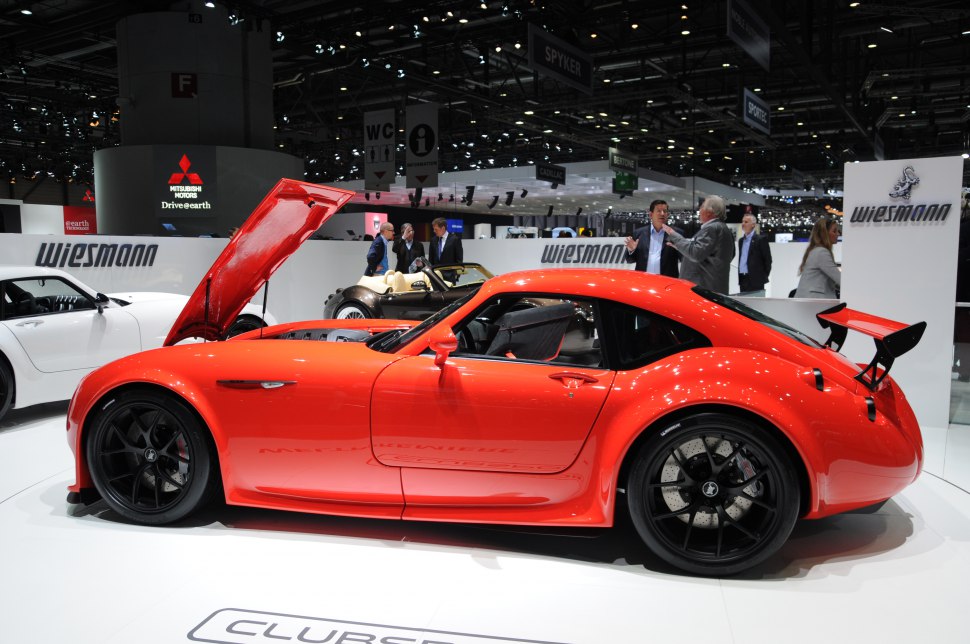 Red sports coupe with open hood and rear wing