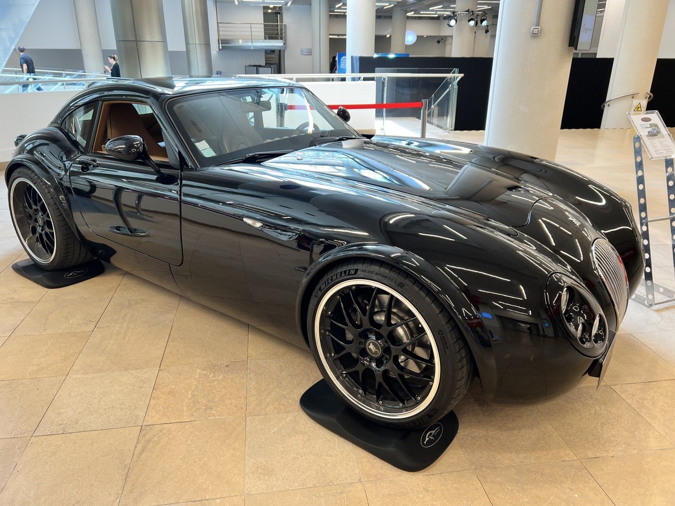 Glossy black coupe with sporty black alloy wheels and retro-inspired design