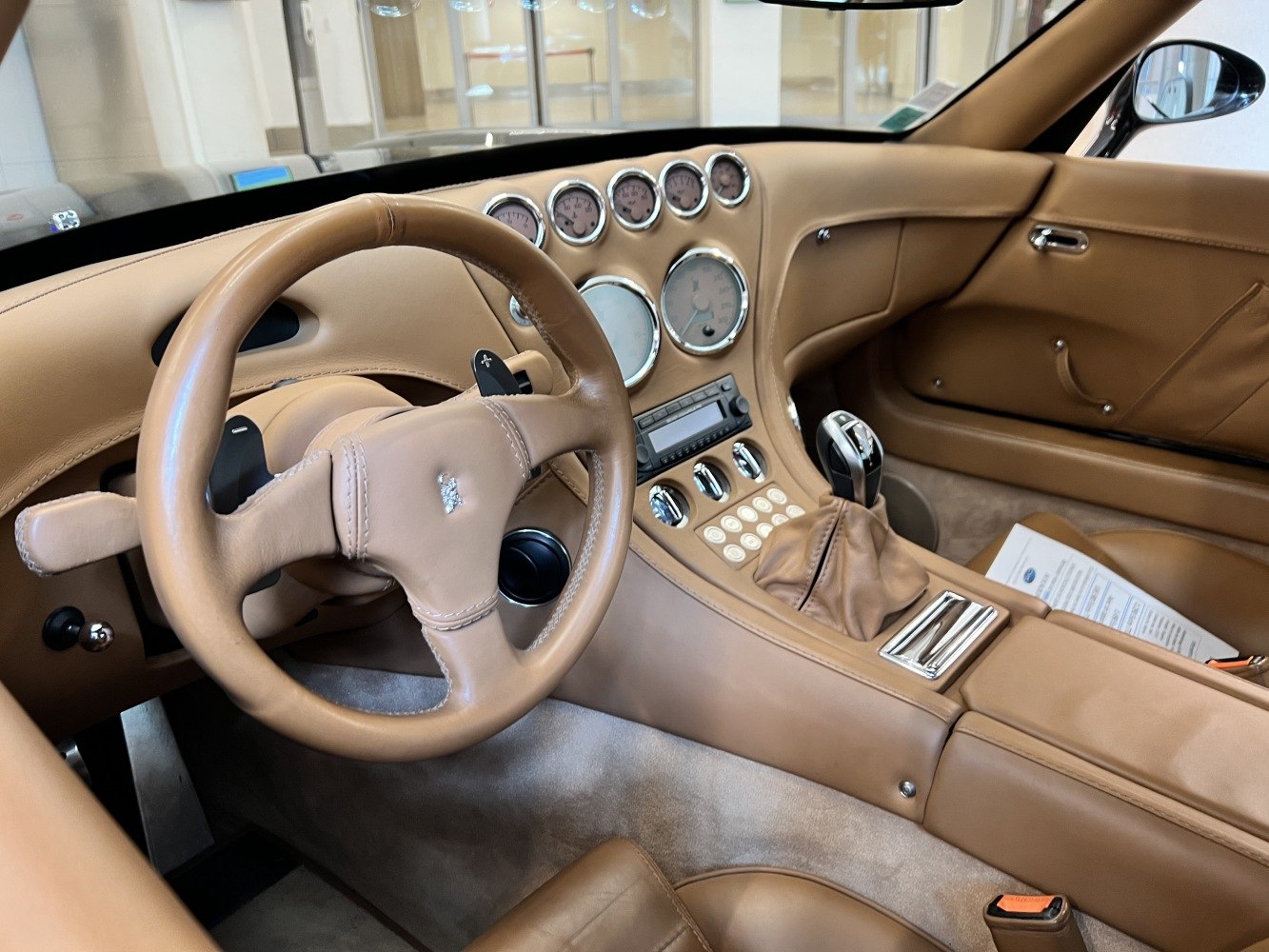Tan leather interior with stitched steering wheel and classic round gauges