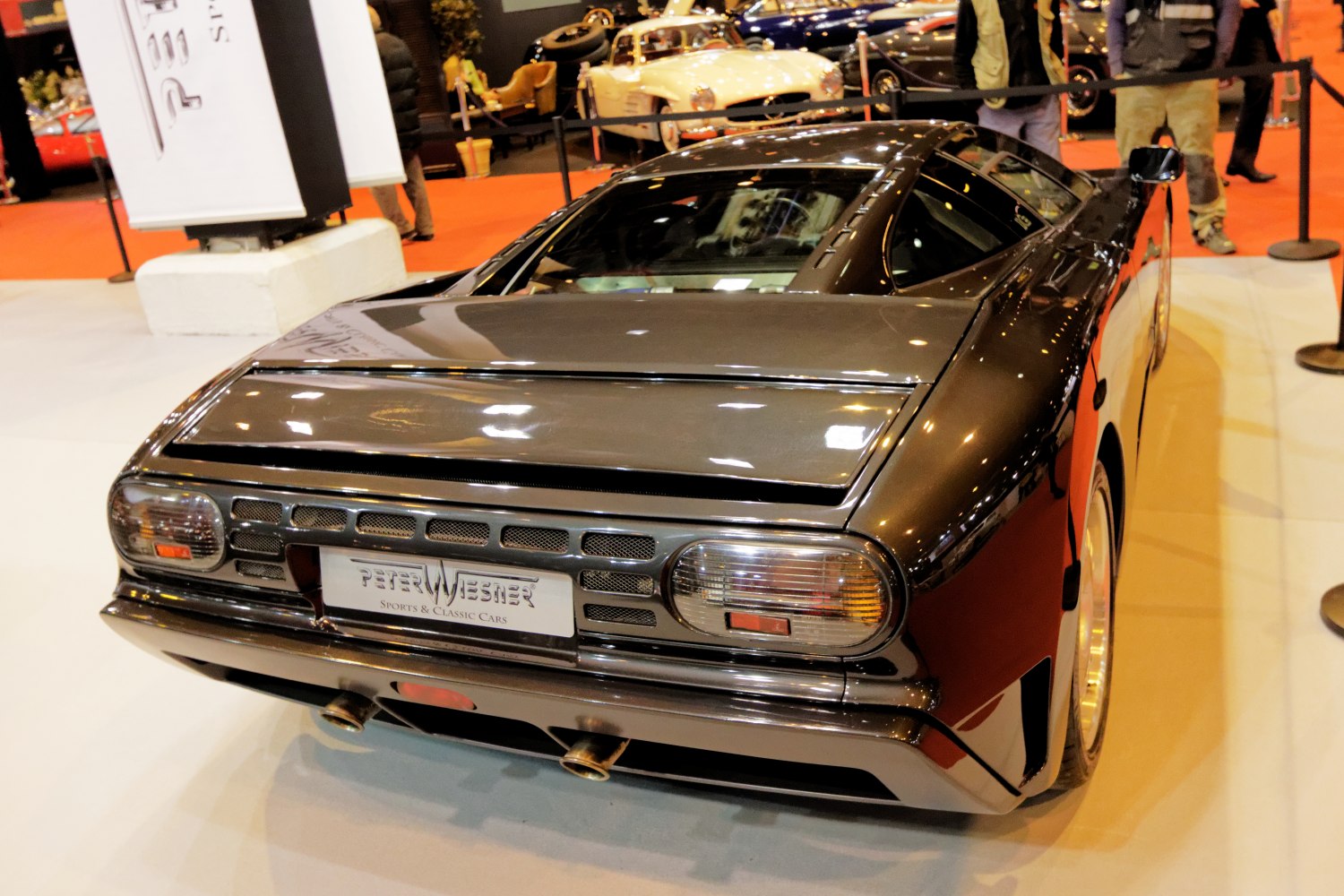 Sleek black sports car rear with dual exhaust and taillights