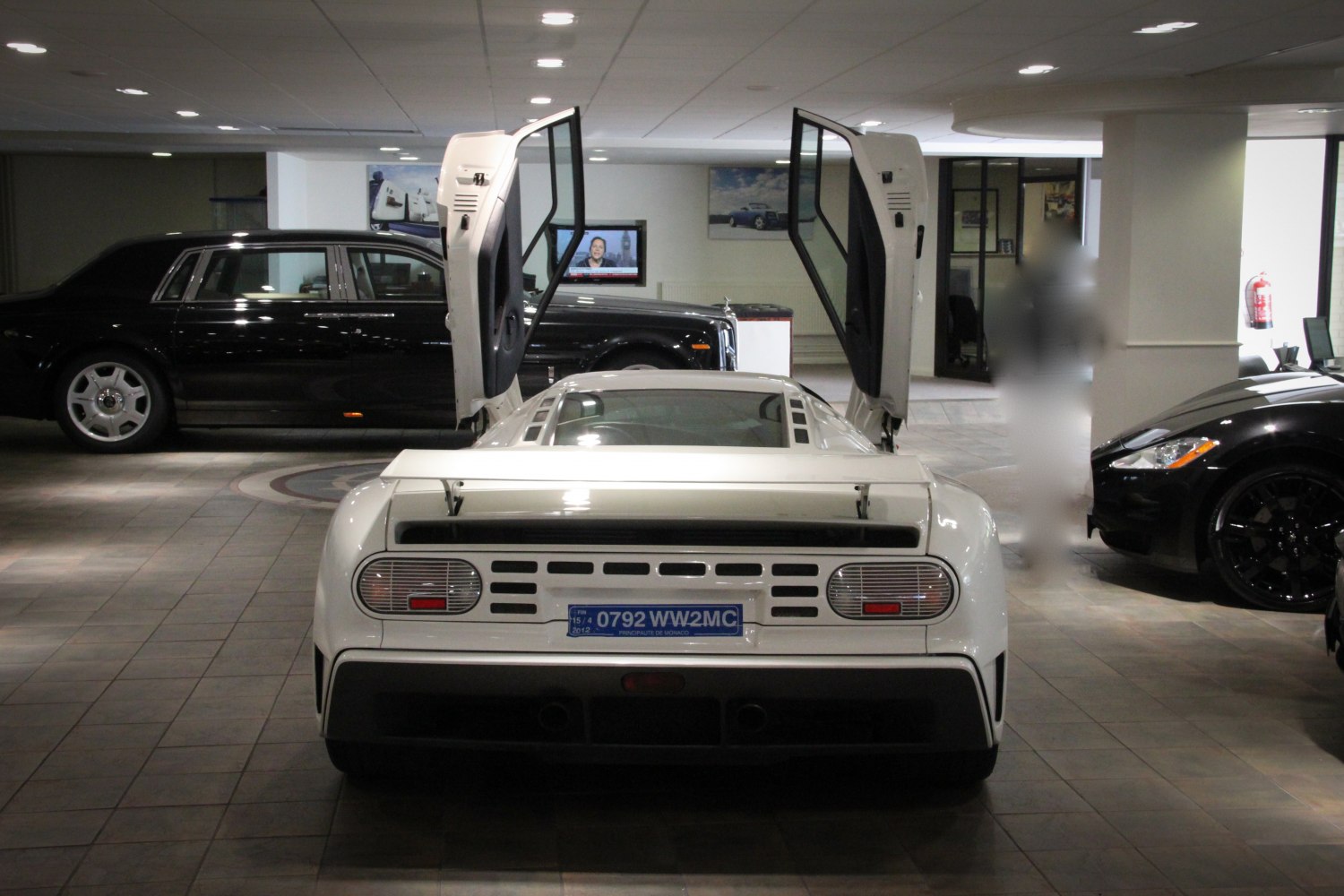White sports car rear with open butterfly doors