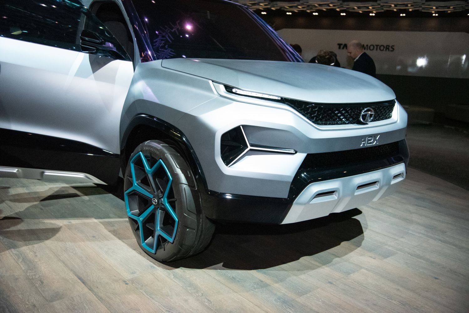 Futuristic LED headlights and blue-accented alloy wheels on a concept SUV front.