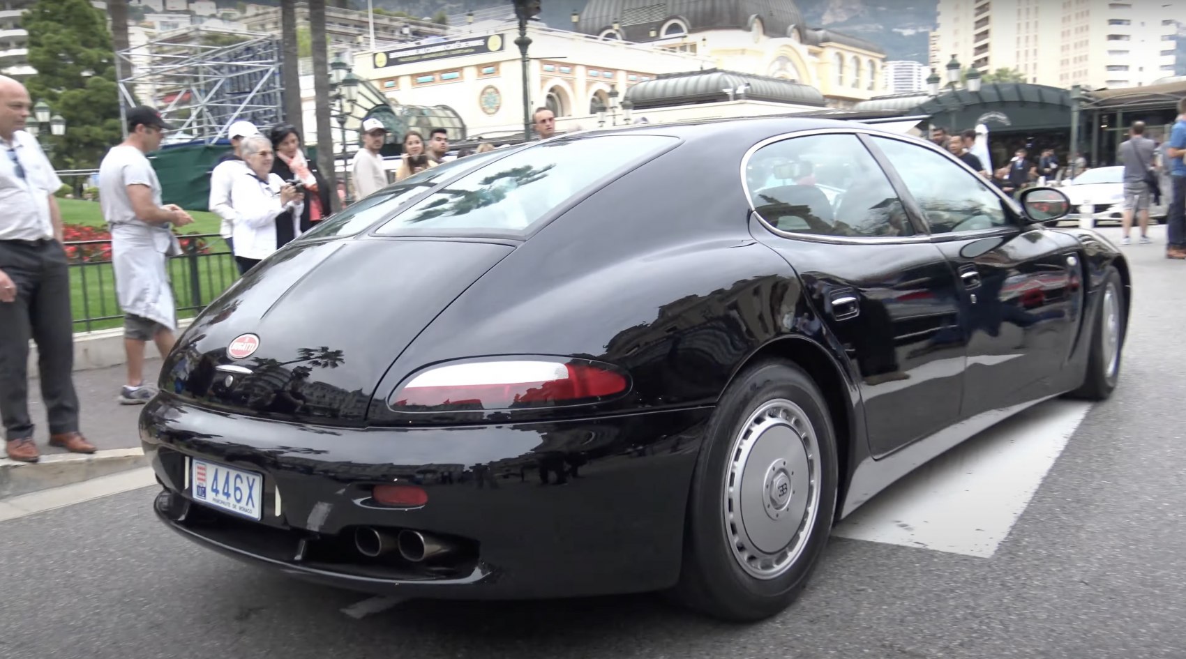 Sleek black luxury sedan rear with quad exhaust and smooth curved design