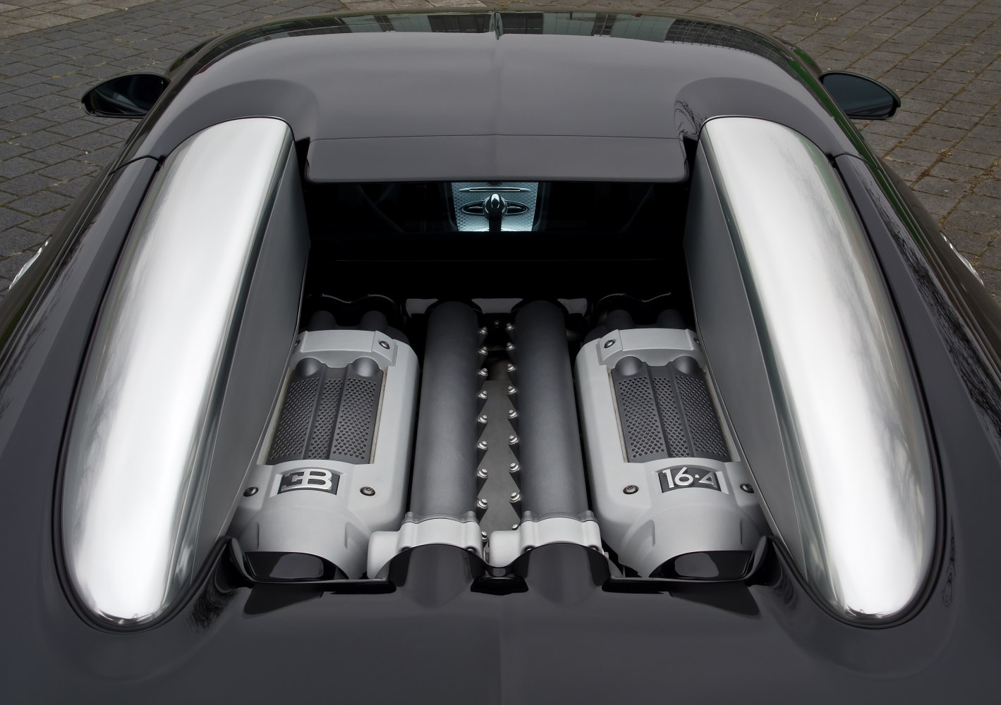 Close-up of a high-performance V16 engine with distinctive dual silver intake covers
