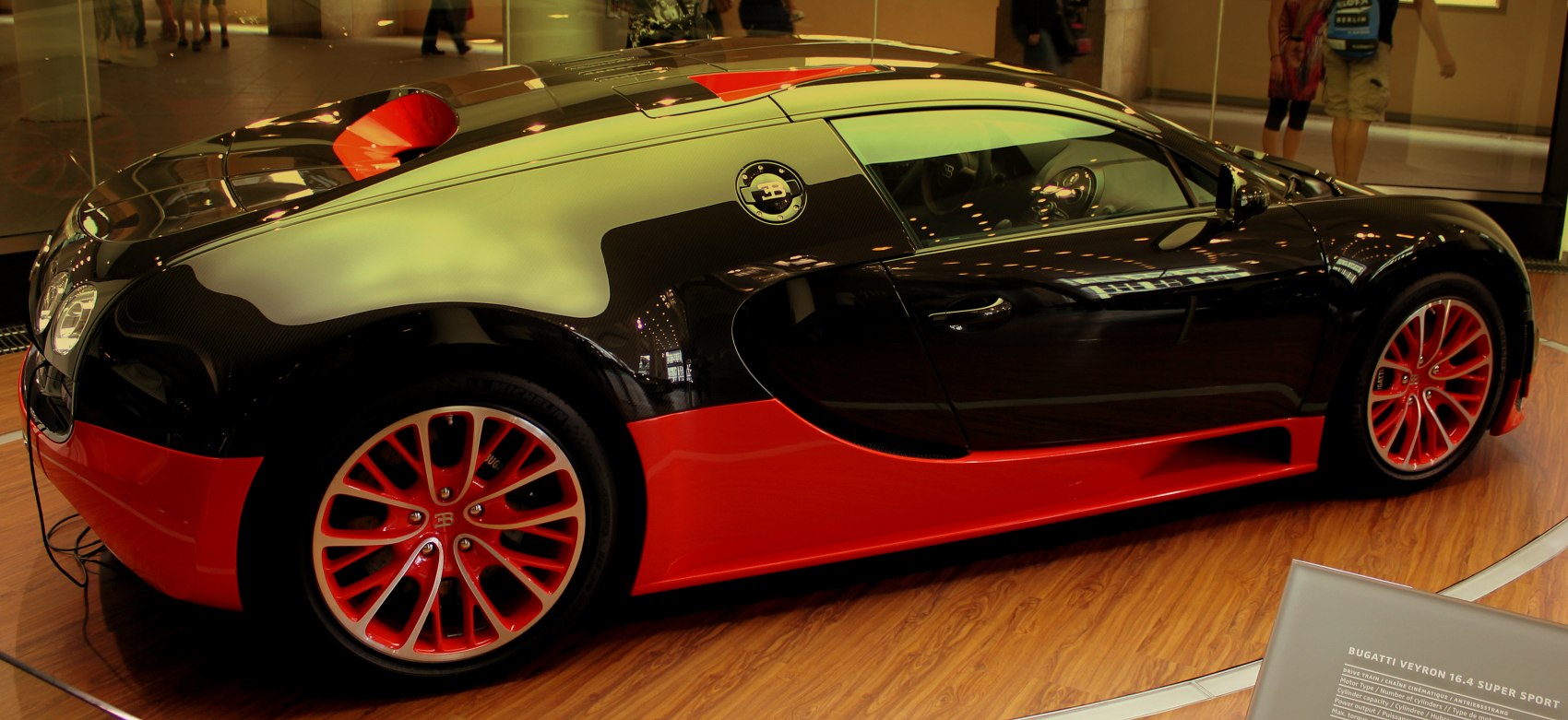 Side profile with striking black and red paint and red multi-spoke rims