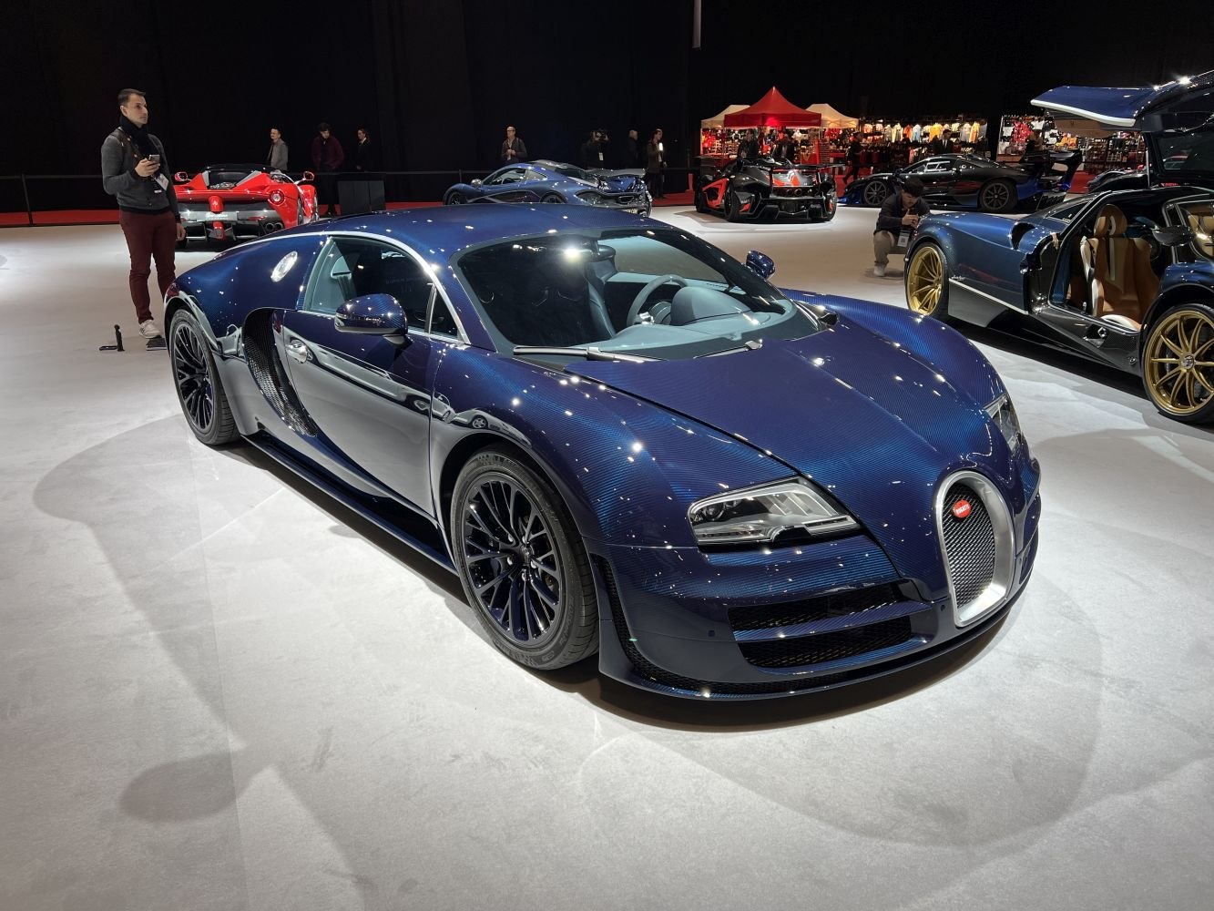 Sleek blue sports coupe with carbon fiber detailing and aerodynamic body.
