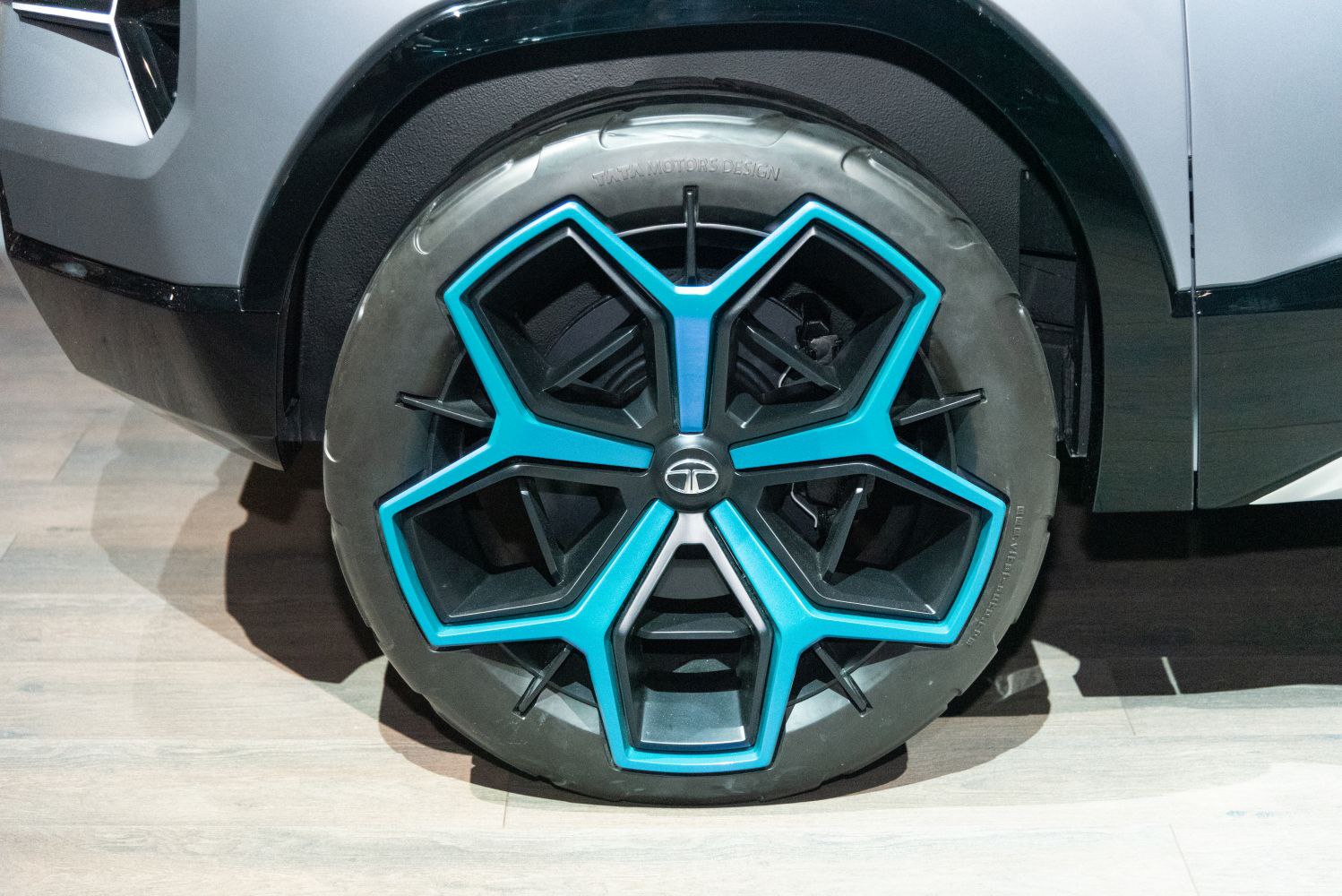Blue and black multi-spoke alloy wheel with geometric design and brand logo center
