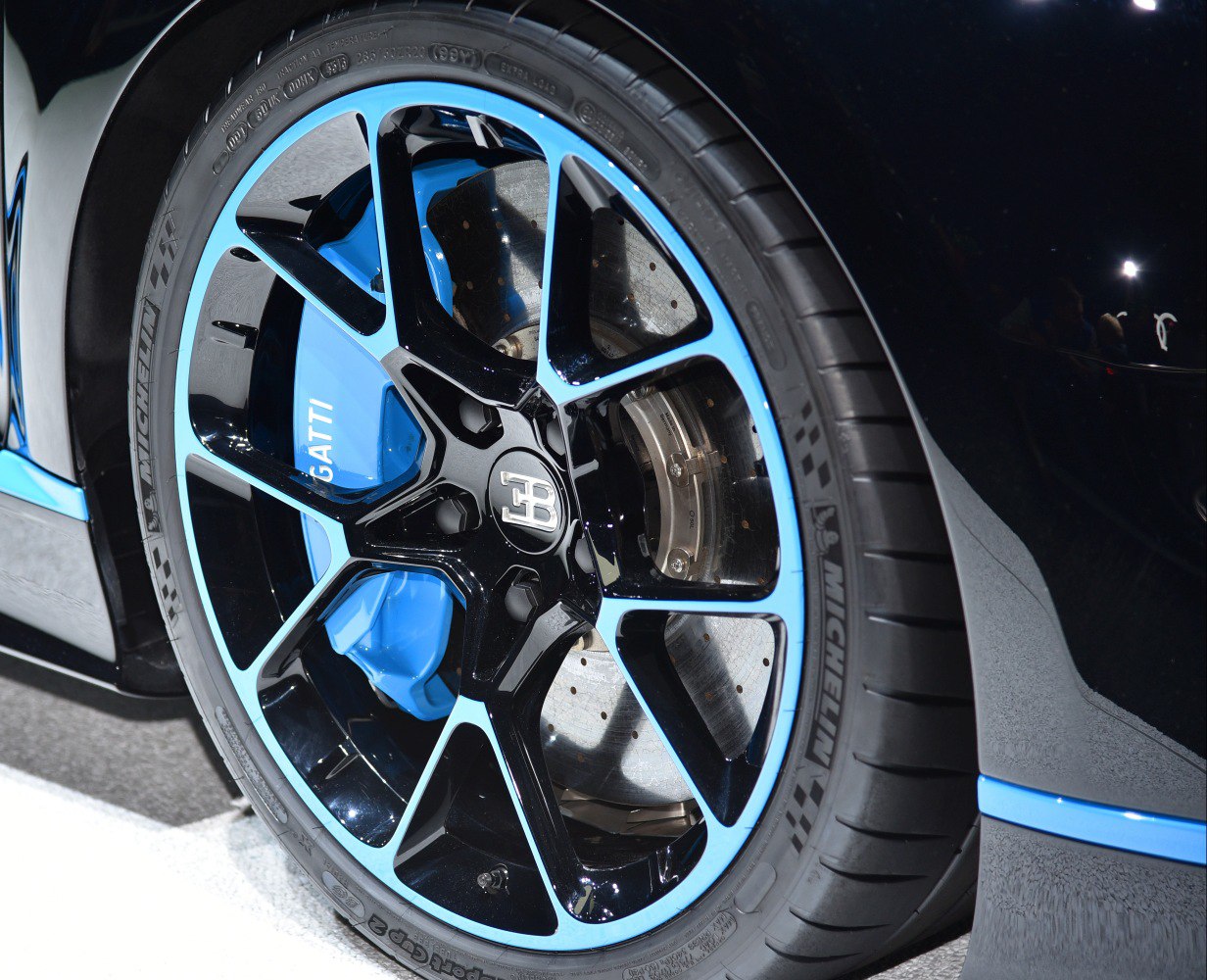 Close-up of a black and blue wheel with blue brake caliper and Michelin tire