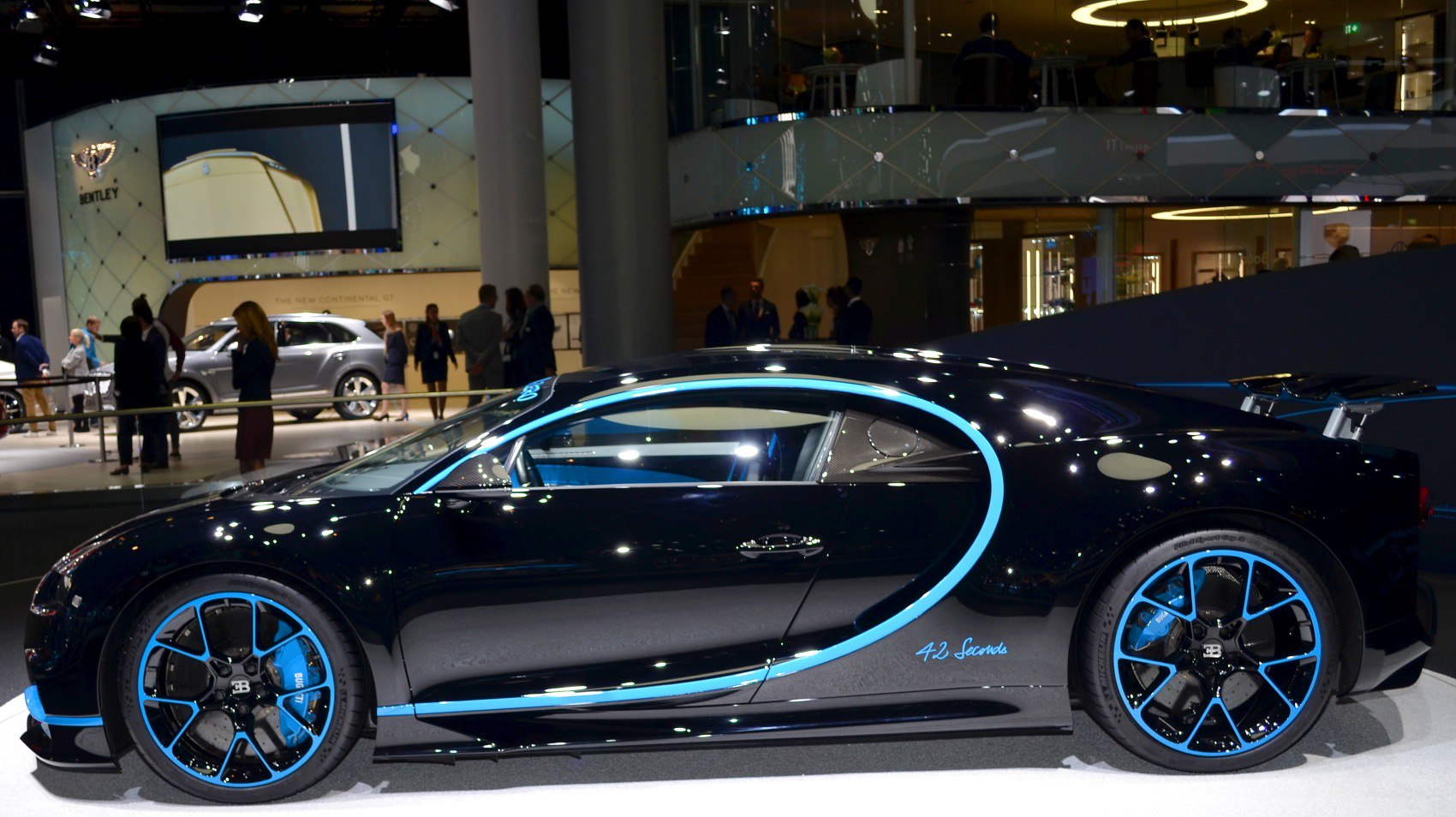 Side profile of black sports coupe with illuminated blue trim and matching blue rims