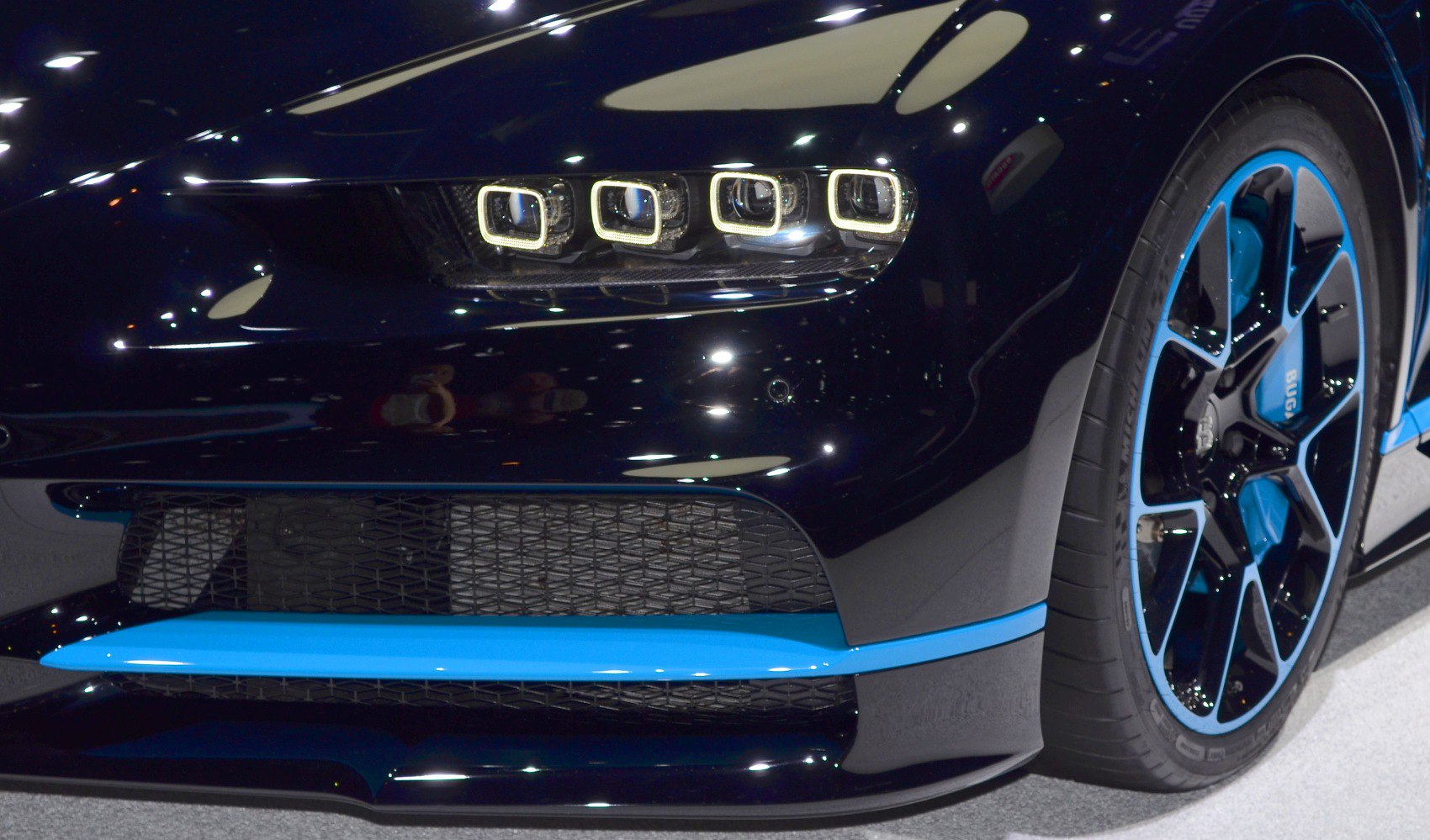 Front headlight and blue-accented wheel rim close-up