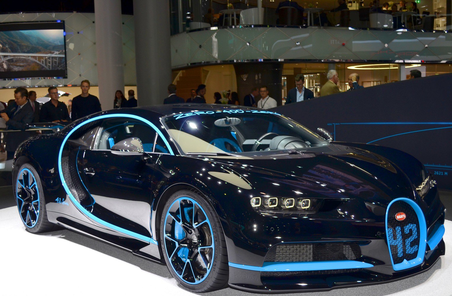 Luxury supercar with black body and blue trim, LED headlights, sporty wheels.